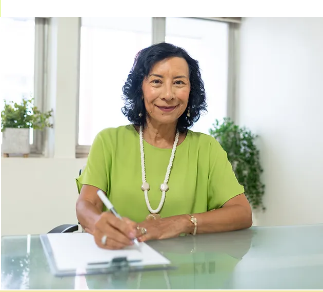 Célia Burgos escrevendo em seu consultório